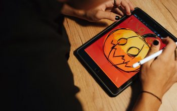 Creating a Halloween pumpkin illustration on a tablet with a stylus.